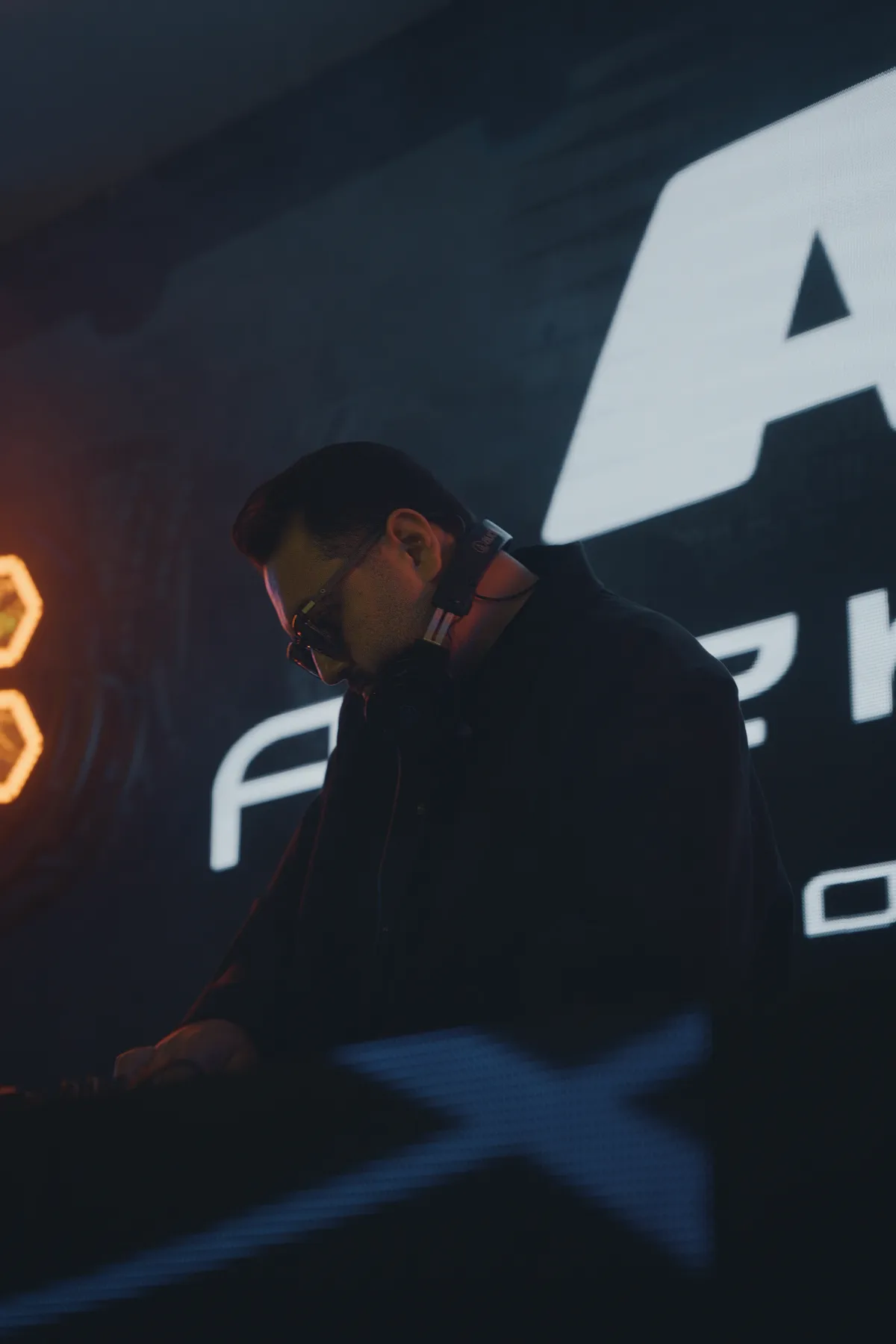 DJ Mehras mixing in front of a big LED stage screen